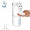 Foam soap dispenser with hand pressing it, USB cable on a white background